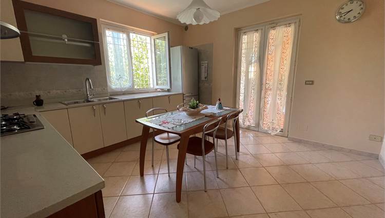 Cucina abitabile con portafinestra verso patio